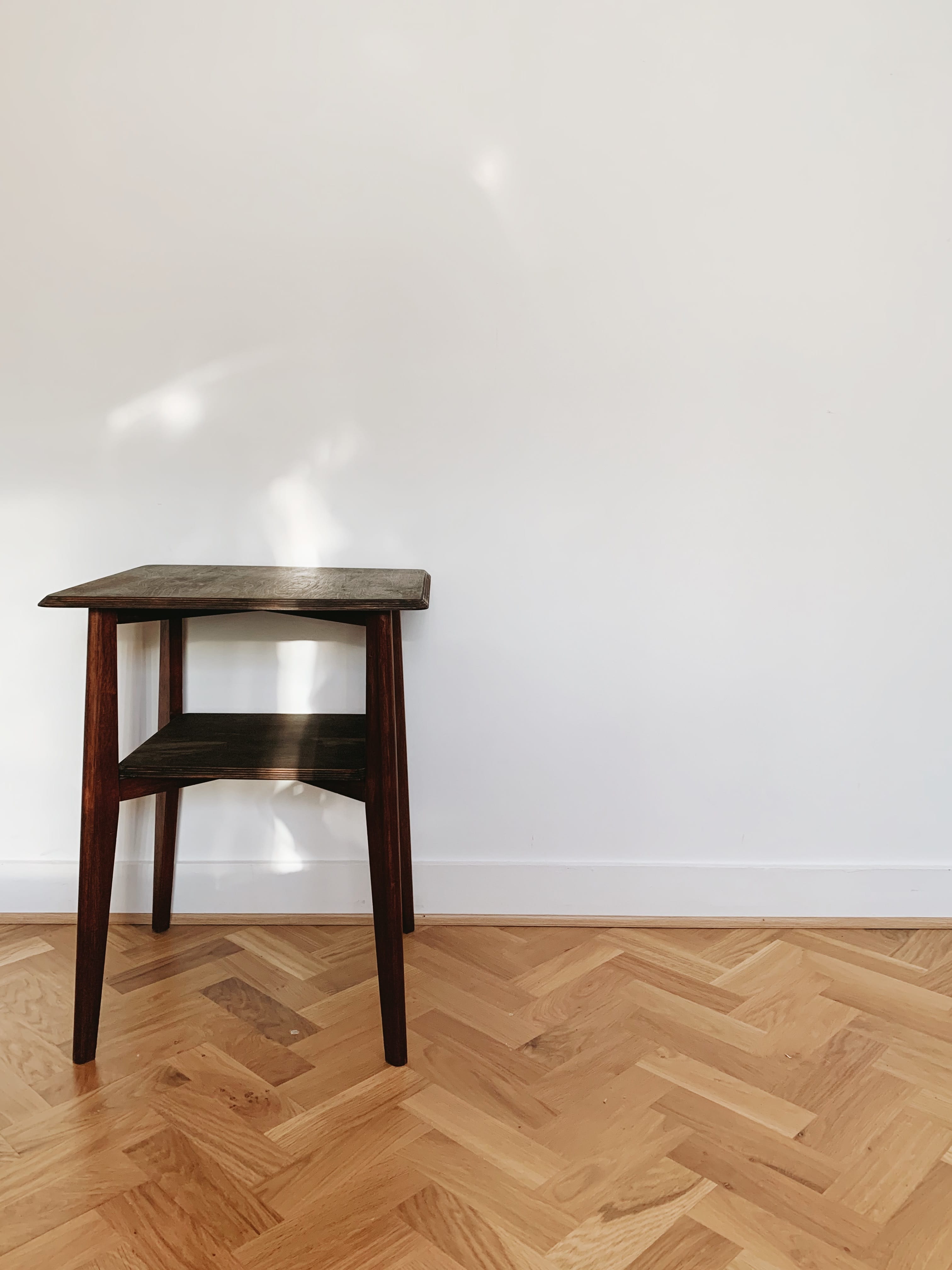 Minimalist wooden table against blank wall